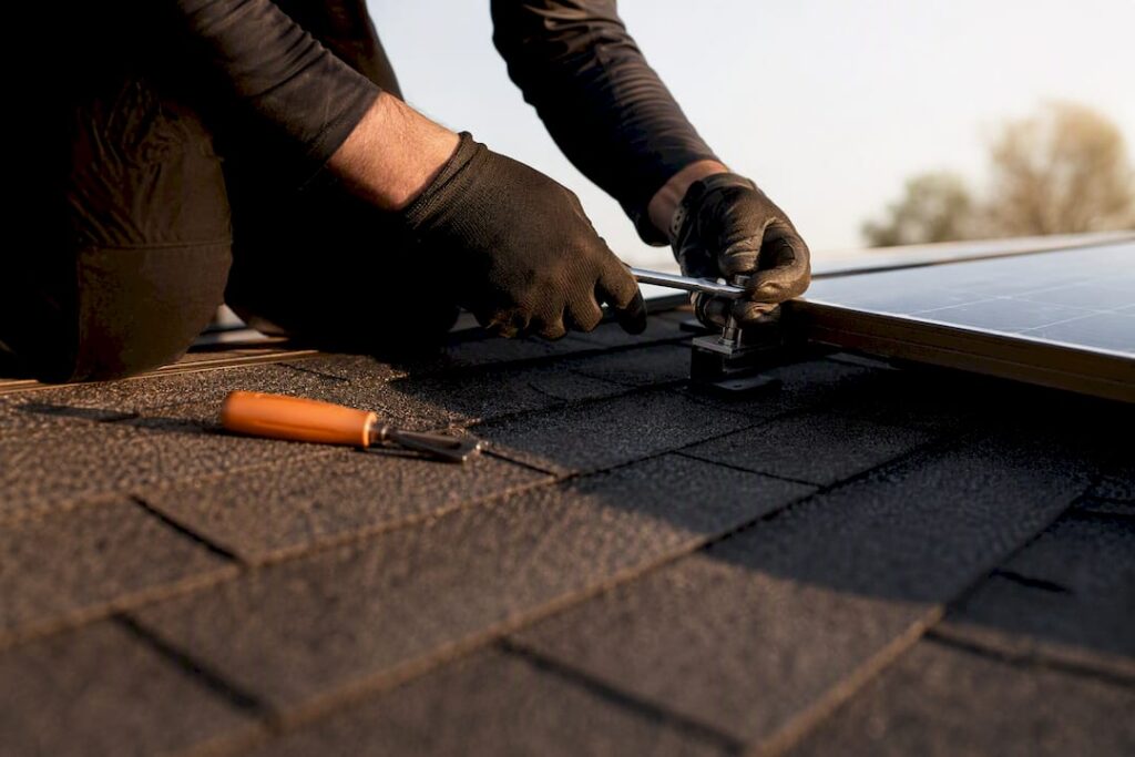 Technician detaching solar panel during roof repair